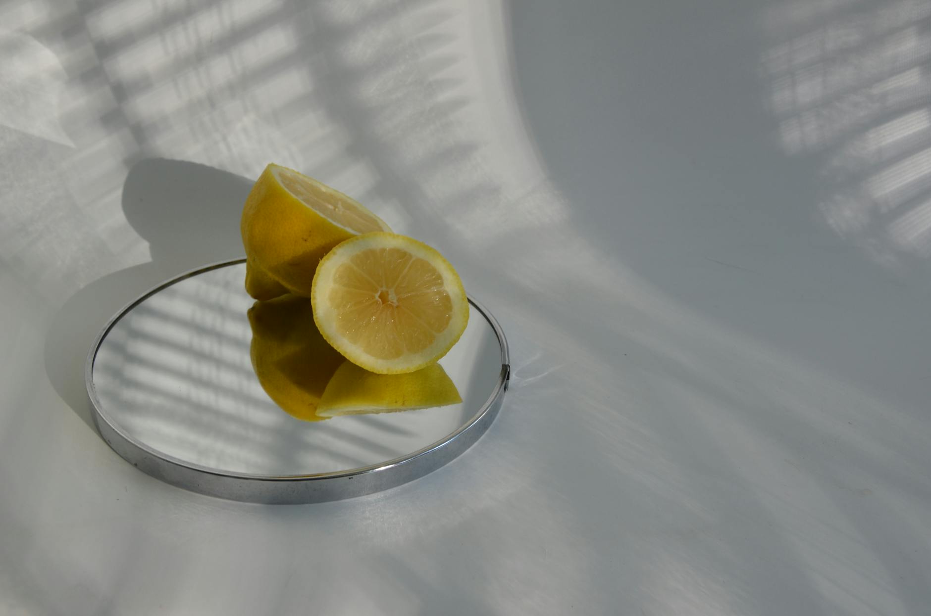 Hand holding a lemon on soft pink background, representing the citrus-inspired sensitivity changes from antihistamine use