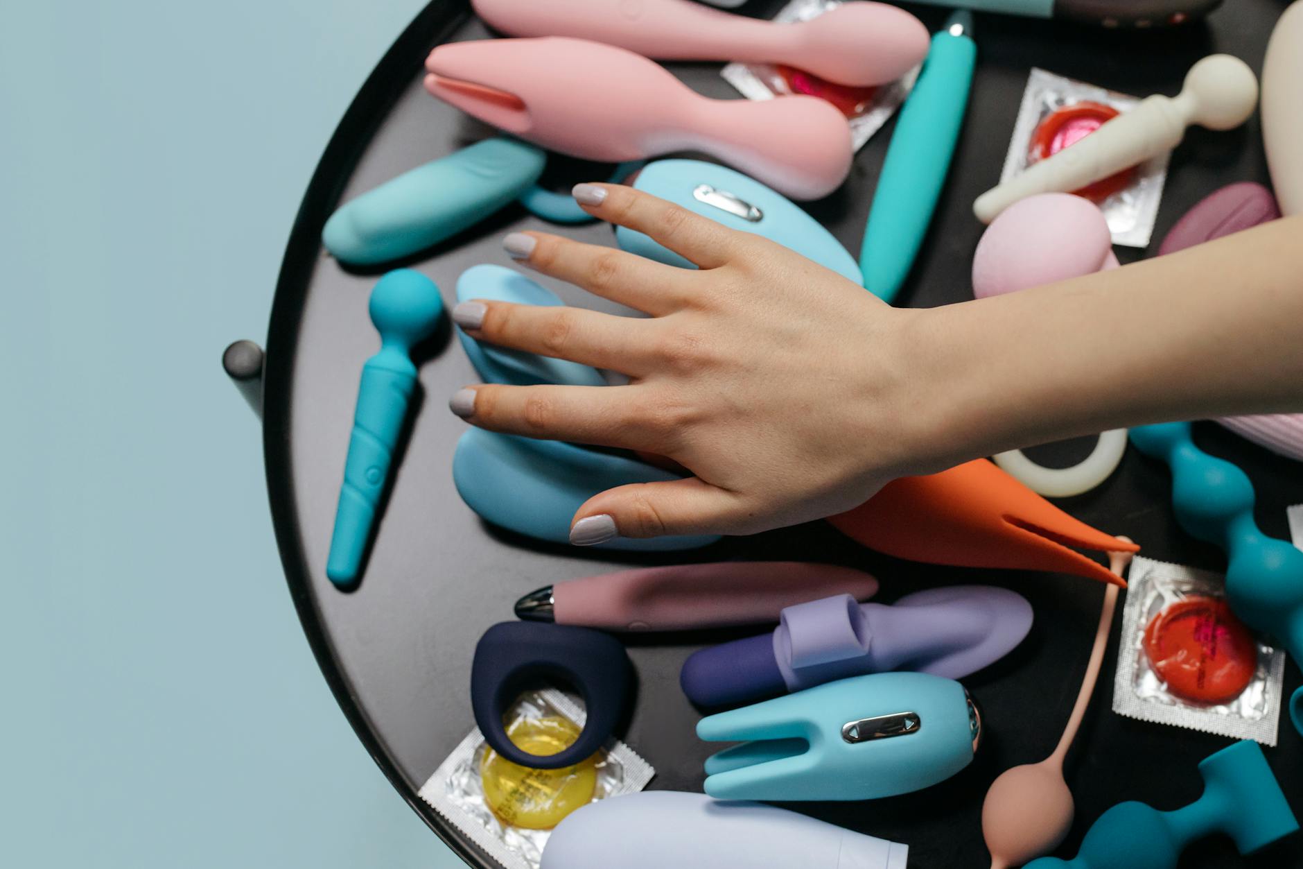 Close-up of hands gently holding a blue lemon vibrator against a soft purple background