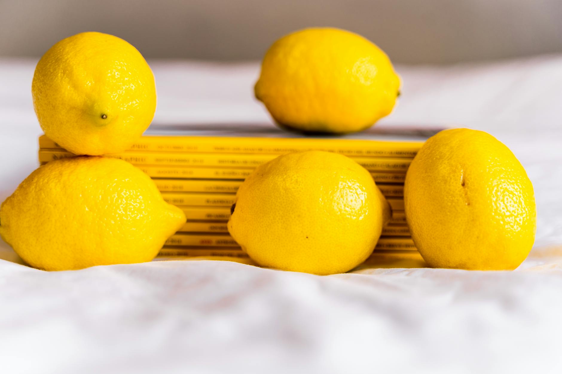 Whole lemons stacked with books on a white surface, symbolizing fresh solutions to intimacy mismatches